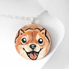 Load image into Gallery viewer, small wood disc painted with a smiling Shiba inu's face. available as a keepsake or pendant necklace 
