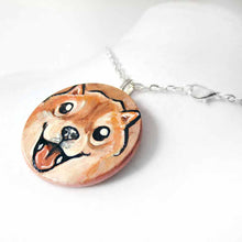Load image into Gallery viewer, small wood disc painted with a smiling Shiba inu's face. available as a keepsake or pendant necklace 
