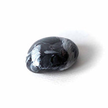 Load image into Gallery viewer, a small beach stone, painted to look like a sleeping baby skunk
