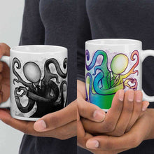 Load image into Gallery viewer, one hand holding a 11 oz white ceramic mug with an illustration of Slender Man forming a heart with his hands. a second hand is holding a second mug, showing it from the other side, featuring the same illustration, mirrored, in all the colours of the rainbow.

