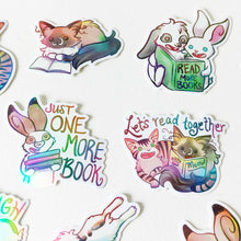 Load image into Gallery viewer, A variety of colorful stickers with cat and rabbit characters from Rainbow of Crazy Comics, each are enjoying books. one sticker has a two rabbits sharing a book, the book cover says "read more books"
