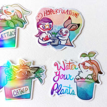 Load image into Gallery viewer, A variety of stickers featuring rabbit and cat characters from Rainbow of Crazy Comics. Some are in a potted plants. One sticker shows a person and a rabbit with the text HYPERFIXATION, another says Water Your Plants, one is labelled CATNIP, and one is labelled LETTUCE.
