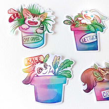 Load image into Gallery viewer, A variety of stickers featuring rabbit and cat characters from Rainbow of Crazy Comics, each in a potted plant. One shows a cat in a pot labelled CAT GRASS, one a rabbit in a pot labelled LETTUCE, one rabbit in a pot labelled KALE
