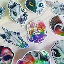 Load image into Gallery viewer, A collection of colourful animal/skull stickers, including possums, cats, chinchilla, unicorn, sloth, Comic Jo wearing a deer skull, and other animal skull designs.
