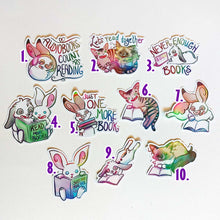 Load image into Gallery viewer, Ten stickers featuring cute cartoon rabbits and cats reading books. 1) English spot rabbit with headphones on. "Audiobooks count as reading." 2) A tabby cat watches a ragdoll cat read a book out loud. "Let's read together." 3) A mini lop rabbit looks at a tablet. "Never enough books." 4) A mini lop and white rabbit share a book that says, "Read more books." 5-10) Rabbits and cats reading books
