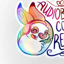 Load image into Gallery viewer, A vinyl rainbow holographic sticker featuring a character from Rainbow of Crazy Comics: a smiling rabbit wearing headphones. the sticker reads, "Audiobooks count as reading"
