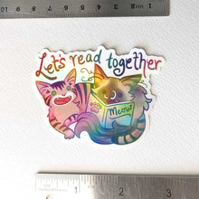 Load image into Gallery viewer, a sticker with two cats from Rainbow of Crazy Comics: a tabby cat next to a ragdoll cat that's holding a book titled "Meow". At the top of the sticker, it says, "Let's read together".

