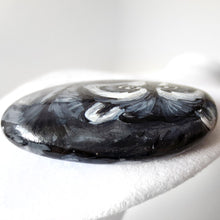Load image into Gallery viewer, the top side of a raccoon painting, painted on a beach stone, showing the raccoon's head

