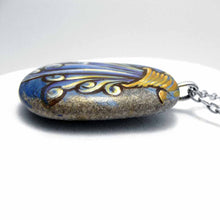 Load image into Gallery viewer, a beach stone hand painted with the symbol of Aquarius: the water bearer. available as a rock art keepsake or pendant necklace
