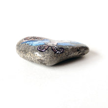 Load image into Gallery viewer, Rock art featuring a painting of a ram on a mountain, in front of a cloudy blue sky. The symbol for Aries is painted on the bottom.
