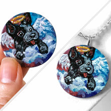 Load image into Gallery viewer, a small wood circle, hand painted with a portrait of an Australian cattle dog as an angel in the clouds, with a halo and wings. available as a keepsake, fridge magnet, or pendant necklace
