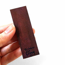 Load image into Gallery viewer, the back of a wood rectangle, signed with, Rainbow of Crazy
