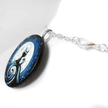 Load image into Gallery viewer, a wood disc, hand painted with a small black cat sitting on a curly hill, against a large full moon and starry night sky. this piece is available as a keepsake o rpendant necklace
