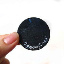 Load image into Gallery viewer, a wood disc, hand painted with a small black cat sitting on a curly hill, against a large full moon and starry night sky. this piece is available as a keepsake o rpendant necklace, signed with rainbow of crazy
