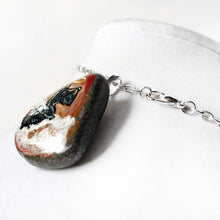 Load image into Gallery viewer, Rock art of a Scottish Terrier as an angel, painted on a small beach stone, this dog portrait is available as a keepsake or a pendant necklace
