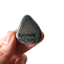 Load image into Gallery viewer, The back of a rock art of a Scottish Terrier as an angel, painted on a small beach stone, signed with, "Rainbow of Crazy"
