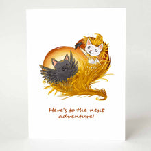 Load image into Gallery viewer, a greeting card features art of a white cat as a scarecrow, on a wheat field, holding a tiny crow, while a black cat dresses up as a crow and dances. the card reads, here's to the next adventure!
