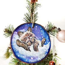 Load image into Gallery viewer, A Christmas tree wood ornament, hand painted with art of a Himalayan cat sleeping on snow.

