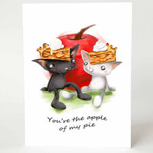 Load image into Gallery viewer, a greeting card with art of a black cat and white cat, both wearing slices of apple pie on their heads. they sit in front of a giant apple. card reads, you're the apple of my pie
