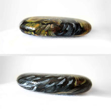Load image into Gallery viewer, a small beach stone, hand painted with the portrait of a Yorkshire terrier dog, its paws painted on the underside
