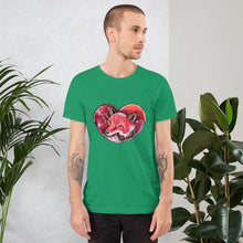 Load image into Gallery viewer, A man is wearing the Fox Love Premium Unisex T-shirt in the colour kelly green, which includes a print of a red fox sleeping in the shape of a heart.
