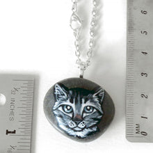 Load image into Gallery viewer, the grey tabby cat portrait stone, available as a necklace, next to two rulers to show its size: 1 5/16" x 15/16" or 3.4 cm x 2.3 cm and weighs approximately 12.5 grams or 0.44 ounces
