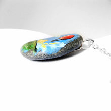 Load image into Gallery viewer, a small rock art of a red hot air balloon, floatiing in the sky over a green landscape, sun shining. available as a keepsake or pendant necklace

