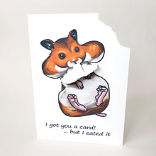 Load image into Gallery viewer, A greeting card featuring art of a Syrian hamster with big, full cheeks, with the text, "I got you a card! ... but I eated it". The top right corner of the card is ripped off and is attached to the hamster's mouth.
