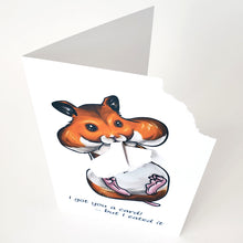 Load image into Gallery viewer, A greeting card featuring art of a golden hamster with big, full cheeks, with the text, "I got you a card! ... but I eated it". The top right corner of the card is ripped off and is attached to the hamster's mouth.
