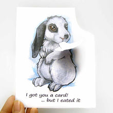 Load image into Gallery viewer, a greeting card with art of a white and gray mini lop rabbit. The card reads, "I got you a card! ... but I eated it". be the top right corner of the card is ripped and hangs from the rabbit's mouth
