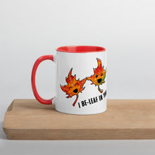 Load image into Gallery viewer, Ah 11 oz white ceramic mug with red handle and interior, printed on the front and back with art of two maple leaves, and the words, "I be-leaf in you"
