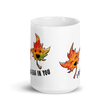 Load image into Gallery viewer, A 15 oz white ceramic mug, printed with art of two maple leaves with happy faces, and the words. "I be-leaf in you"

