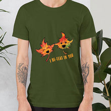 Load image into Gallery viewer, A man wearing the I Believe in You Leaf Premium Unisex T-Shirt in the colour olive green, which includes art of two maple leaves and the words, "I be-leaf in you"
