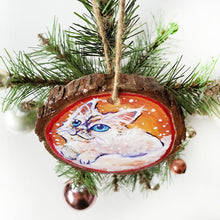 Load image into Gallery viewer, A wooden ornament with a painting of a white Ragamuffin cat with blue eyes, watching the snow fall

