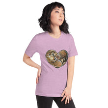 Load image into Gallery viewer, A woman wearing the Otters Love Premium Unisex T-Shirt in the colour heather prism lilac, which includes a graphic of two otters forming the shape of a heart.
