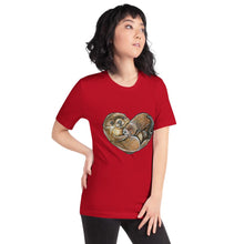 Load image into Gallery viewer, A woman wearing the Otters Love Premium Unisex T-Shirt in the colour red, which includes art of two otters forming the shape of a heart.
