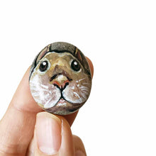 Load image into Gallery viewer, a small beach stone, hand painted with the fact of a creme d'Argent rabbit, available as a keepsake or pendant necklace
