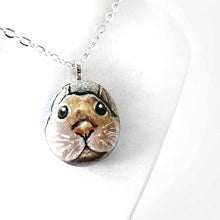 Load image into Gallery viewer, a small beach stone, hand painted with the fact of a creme d'Argent rabbit, available as a keepsake or pendant necklace
