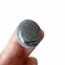 Load image into Gallery viewer, a small beach stone, hand painted with the fact of a creme d'Argent rabbit, available as a keepsake or pendant necklace, back signed with, Rainbow of Crazy
