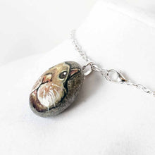 Load image into Gallery viewer, a small beach stone, hand painted with the fact of a creme d'Argent rabbit, available as a keepsake or pendant necklace
