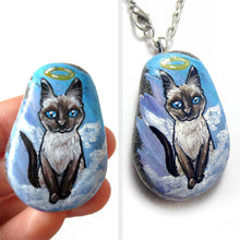 Load image into Gallery viewer, art of a siamese cat as an angel, is hand painted on a river rock, and is available as either a keepsake, fridge magnet,
 or a pendant necklace
