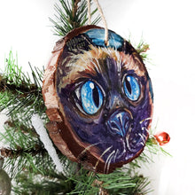 Load image into Gallery viewer, A Christmas ornament with a painting fo a blue eyed Siamese cat's face
