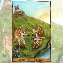 Load image into Gallery viewer, an art print of the six of cups tarot card from the animism tarot. two baby deer play in with crocus flowers in a field, with their mother watching over them in the distance.
