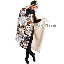 Load image into Gallery viewer, a man wears the Sleepy Cats Hooded Blanket, featuring illustrations of different sleeping cats, lined with micro fleece
