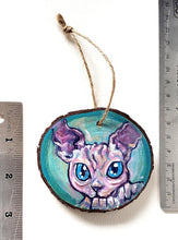 Load image into Gallery viewer, A handmade Christmas tree wood ornament, featuring a painting of a sphynx cat with blue eyes
