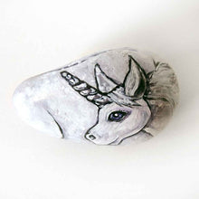 Load image into Gallery viewer, a stone hand painted with the portrait of a unicorn with purple eyes
