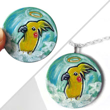 Load image into Gallery viewer, art of a yellow cockatiel as an angel in the clouds, painted on a small wood disc, available as a keepsake or necklace
