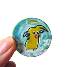 Load image into Gallery viewer, art of a yellow cockatiel as an angel in the clouds, painted on a small wood disc, available as a keepsake or necklace
