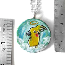 Load image into Gallery viewer, art of a yellow cockatiel as an angel in the clouds, painted on a small wood disc, available as a keepsake or necklace

