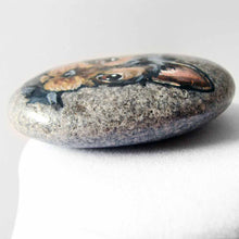 Load image into Gallery viewer, a beach stone, hand painted with the portrait of a black and brown yorkie's face
